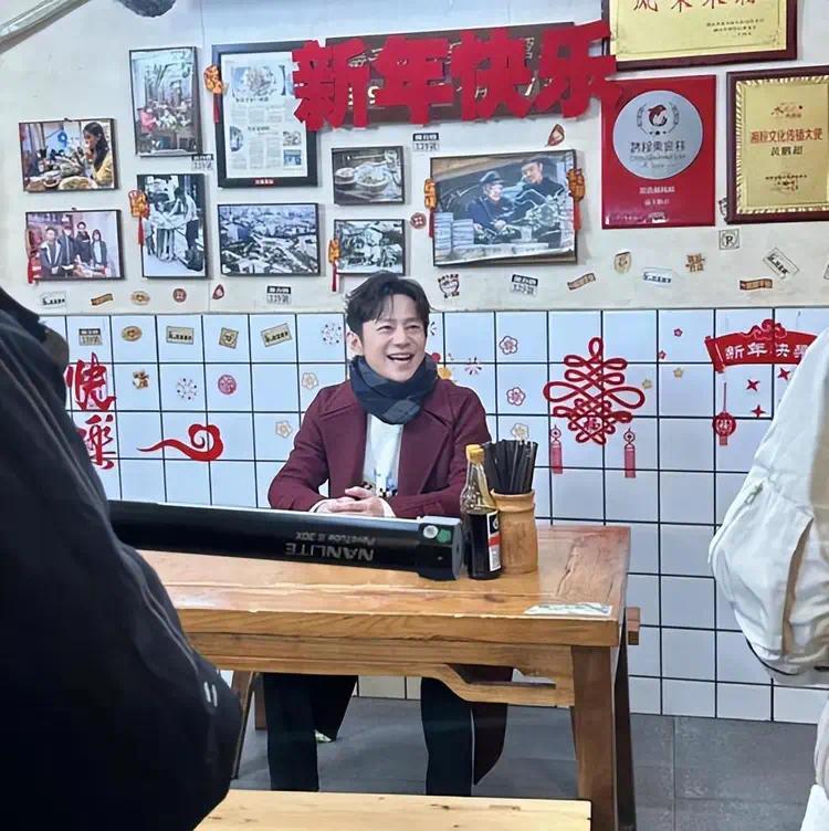 50岁的何炅在长沙独自吃粉被抓拍，穿红大衣超亲切，单身生活也热闹